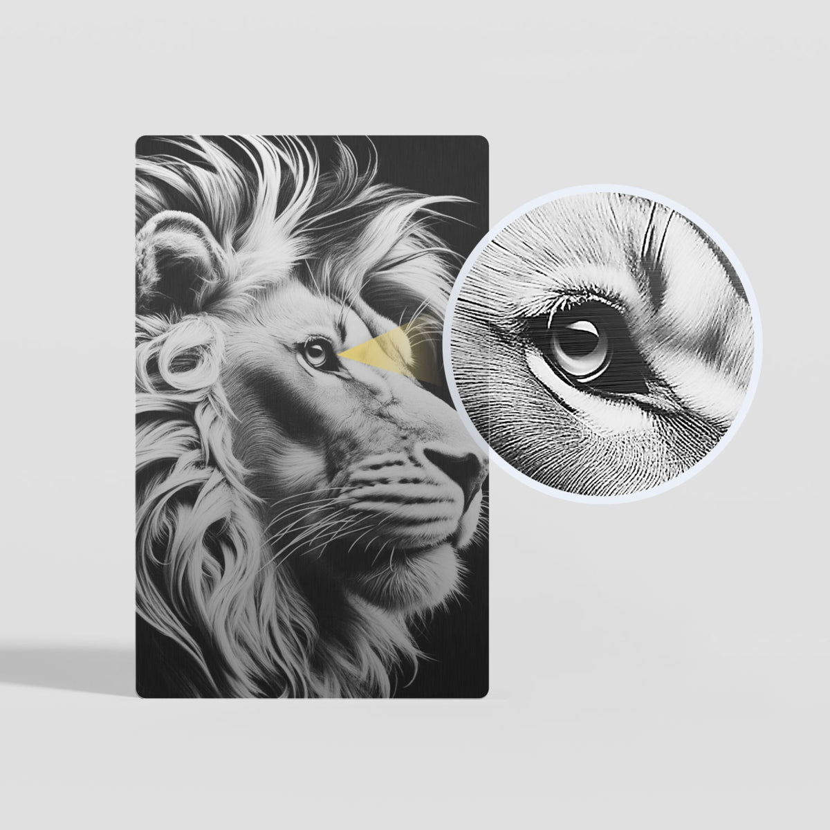 A highly detailed laser-engraved lion portrait on a black metal card, with a close-up inset highlighting the intricate texture of the lion's eye, showcasing the high-precision engraving quality achievable on blank metal card blanks.