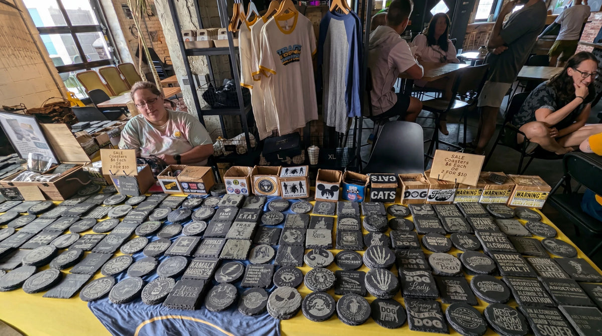 Many engraved stone crafts displayed at a craft fair.