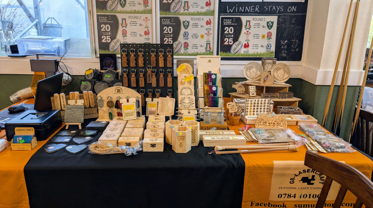 Multiple wooden engraved items displayed on a table.