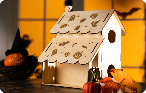 A handcrafted wooden house showcased in a Halloween display.